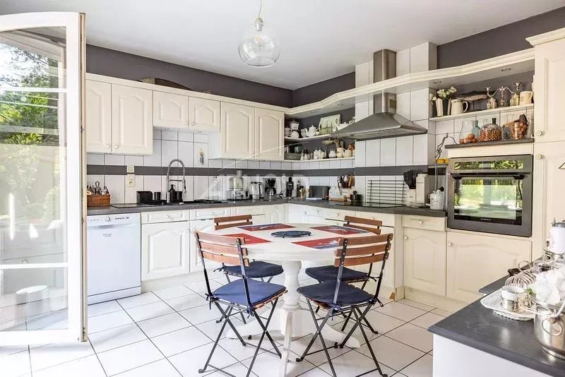 Cuisine moderne et lumineuse d'une maison à Vannes, avec table et chaises, équipements intégrés.