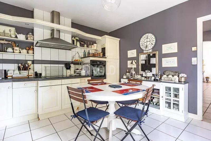 Cuisine moderne avec table à manger et chaises, murs peints en gris à Vannes.
