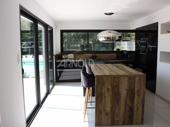 Modern kitchen with central island and view of the outdoor pool.