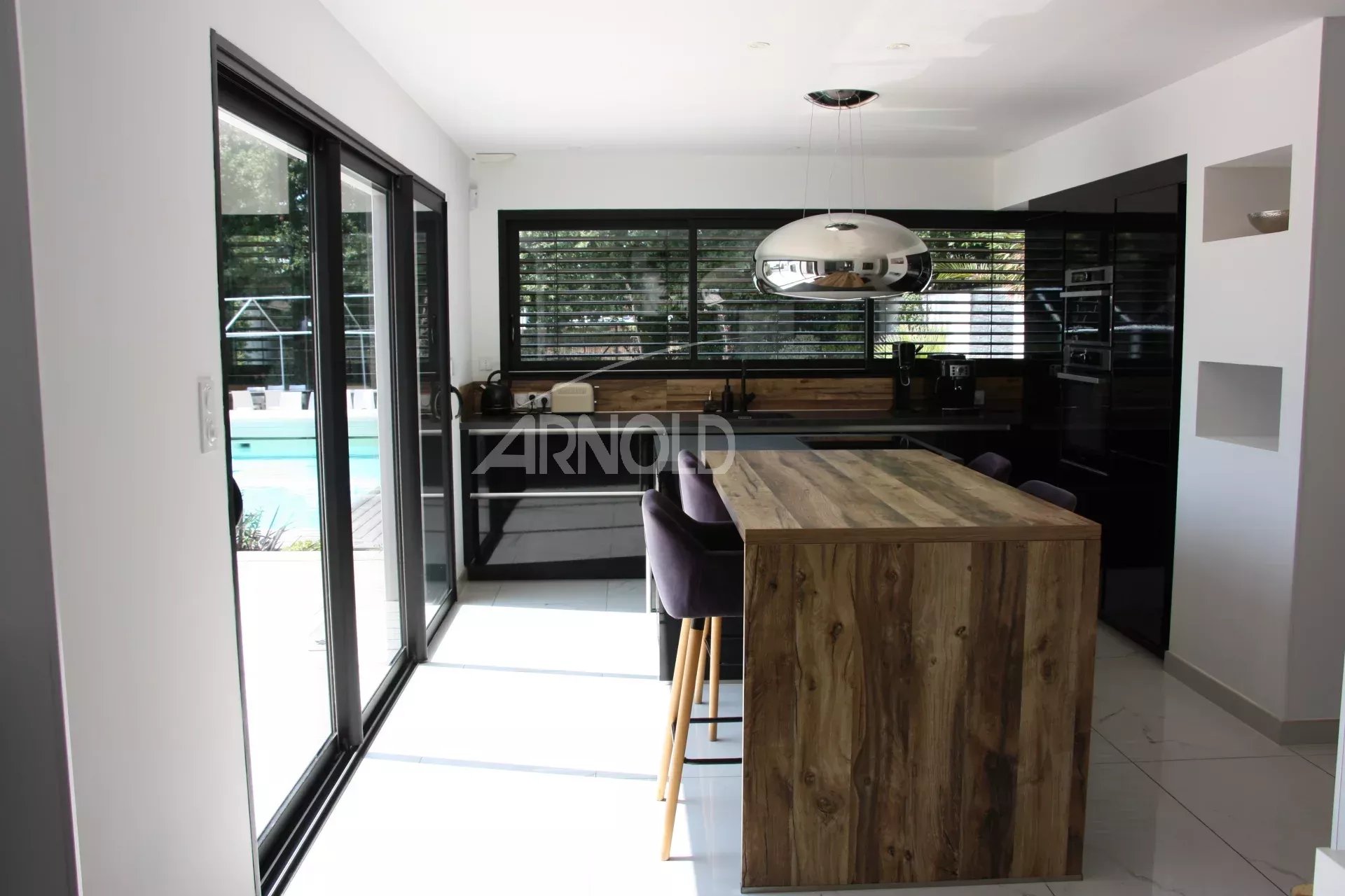 Contemporary kitchen with pool view Modern kitchen with central island and view of the outdoor pool.