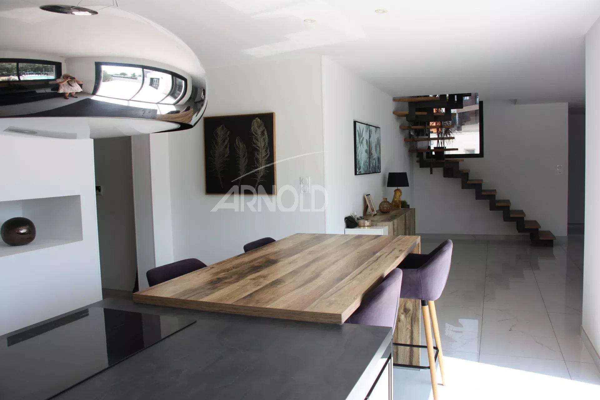 Interior of a contemporary villa in Vannes Interior of a contemporary villa in Vannes, with a large wooden table and a modern staircase.
