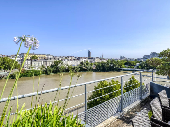 Vue panoramique sur la Loire et Nantes depuis une terrasse de duplex de prestige.