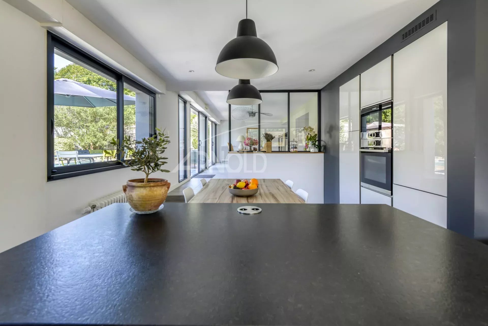 Modern cuisine in Nantes Interior of a modern kitchen with a black worktop and a view of the garden.