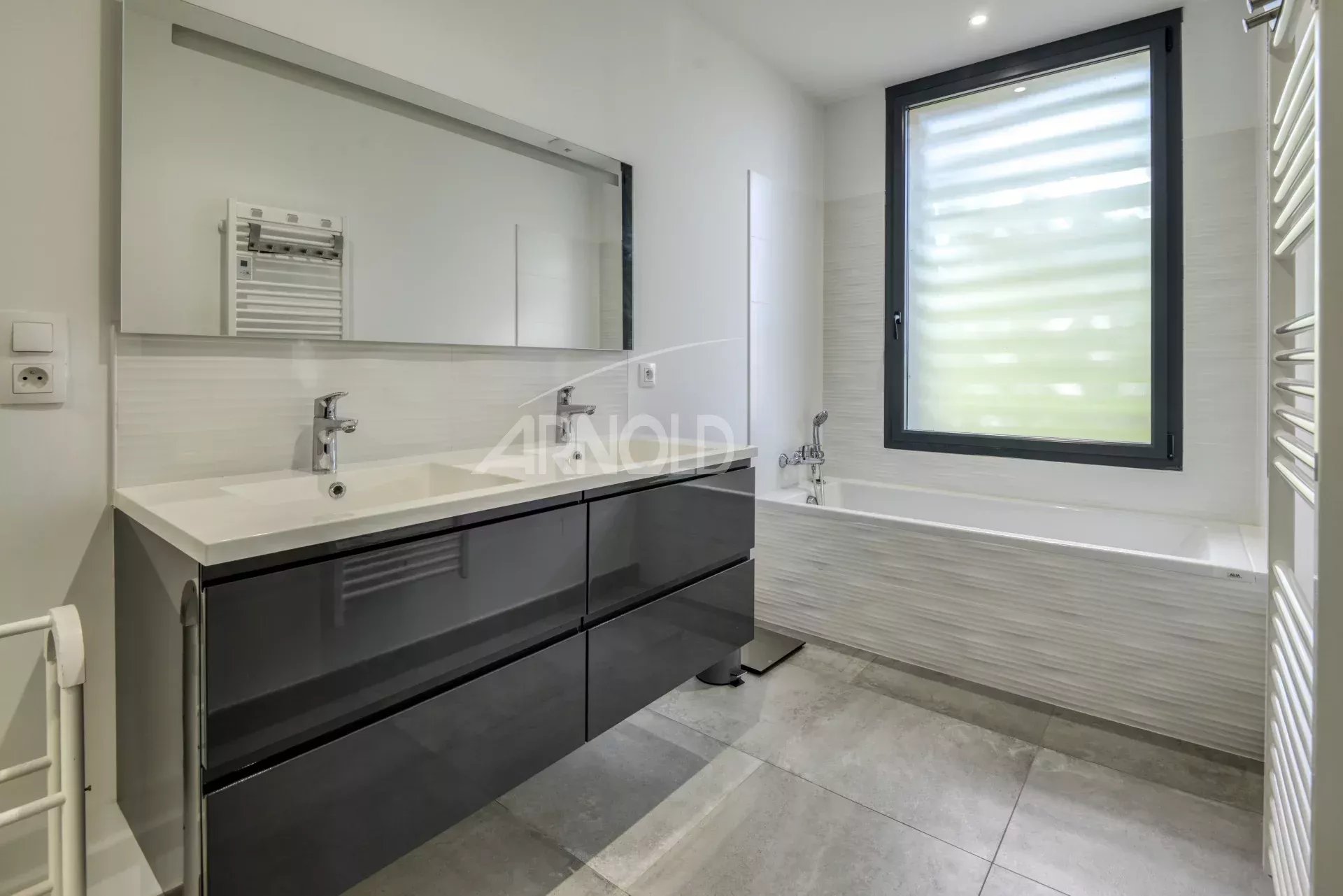 Contemporary bathroom Modern bathroom with bathtub and double sink, light walls and window.