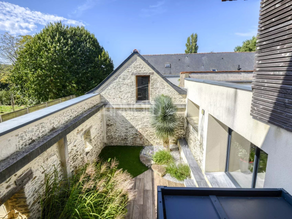 View of an 18th century residence with swimming pool and garden in Nantes, combining authenticity and modernity.