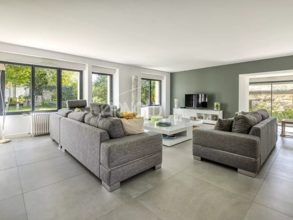 Interior of a modern home with a bright living room and large windows.