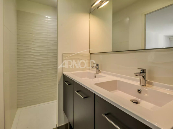 Modern bathroom with shower and double sink.