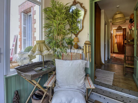 Entrée d'une maison bourgeoise avec une décoration chaleureuse et des plantes.