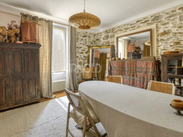 Intérieur d'une maison bourgeoise à Saint-Étienne-de-Montluc avec murs en pierre et mobilier élégant.