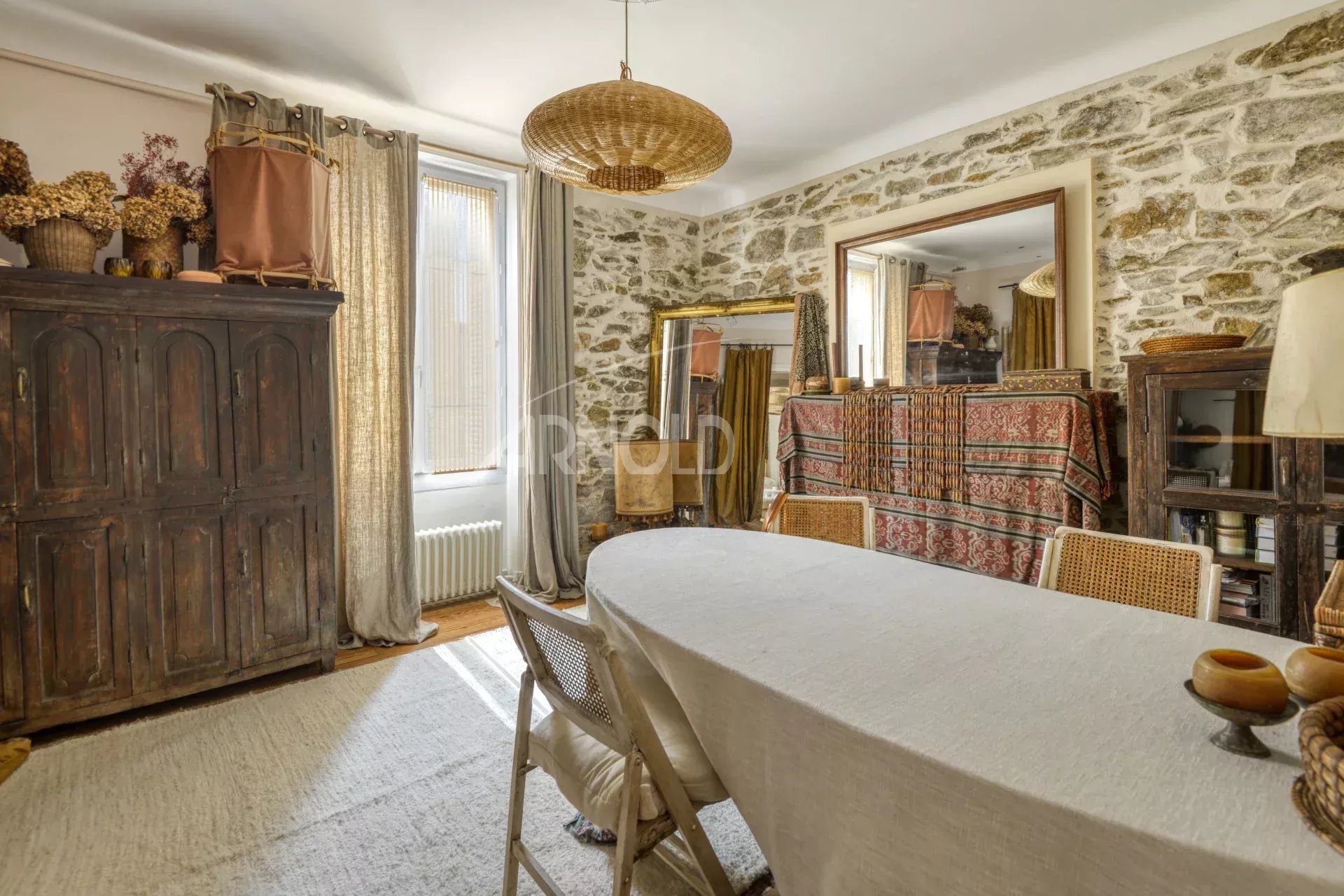 Intérieur d’une maison de charme à Saint-Étienne-de-Montluc Intérieur d'une maison bourgeoise à Saint-Étienne-de-Montluc avec murs en pierre et mobilier élégant.