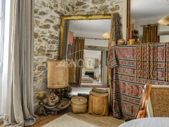 Intérieur d'une maison bourgeoise à Saint-Étienne-de-Montluc avec des éléments décoratifs en pierre et en textile.