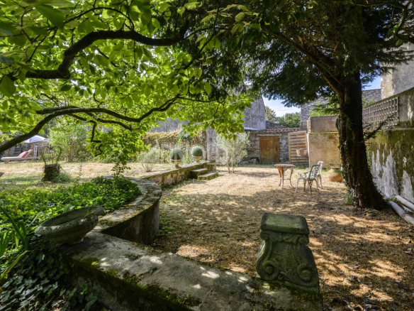 Jardin d'une maison bourgeoise à Saint-Étienne-de-Montluc, avec arbres et mobilier de jardin.