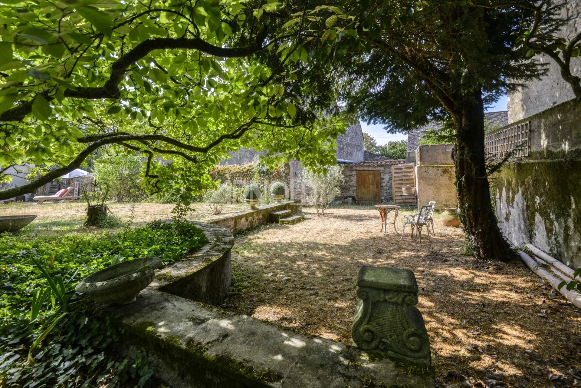 Jardin de maison bourgeoise à Saint-Étienne-de-Montluc Jardin d'une maison bourgeoise à Saint-Étienne-de-Montluc, avec arbres et mobilier de jardin.