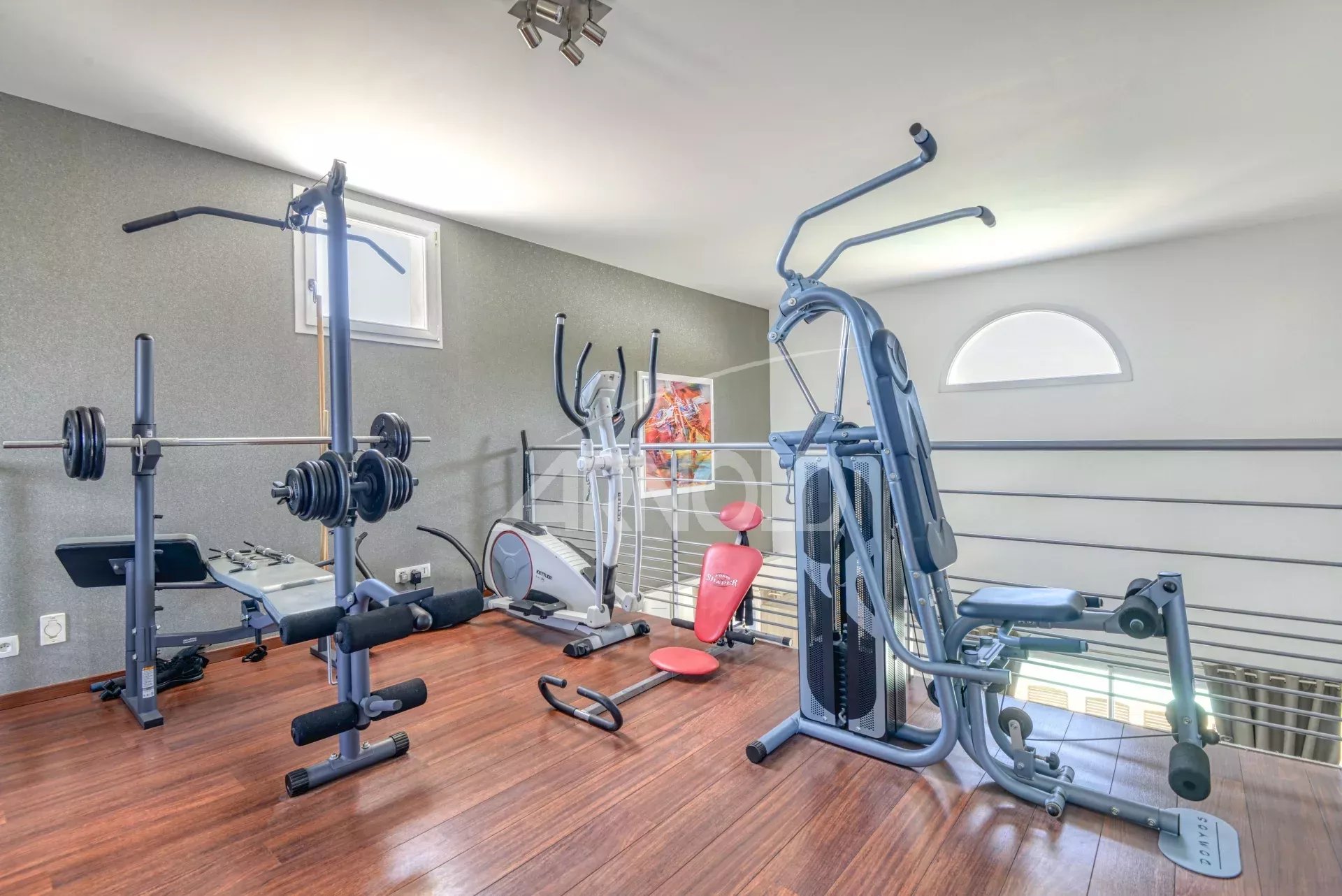 Salle de sport équipée avec divers appareils de fitness.