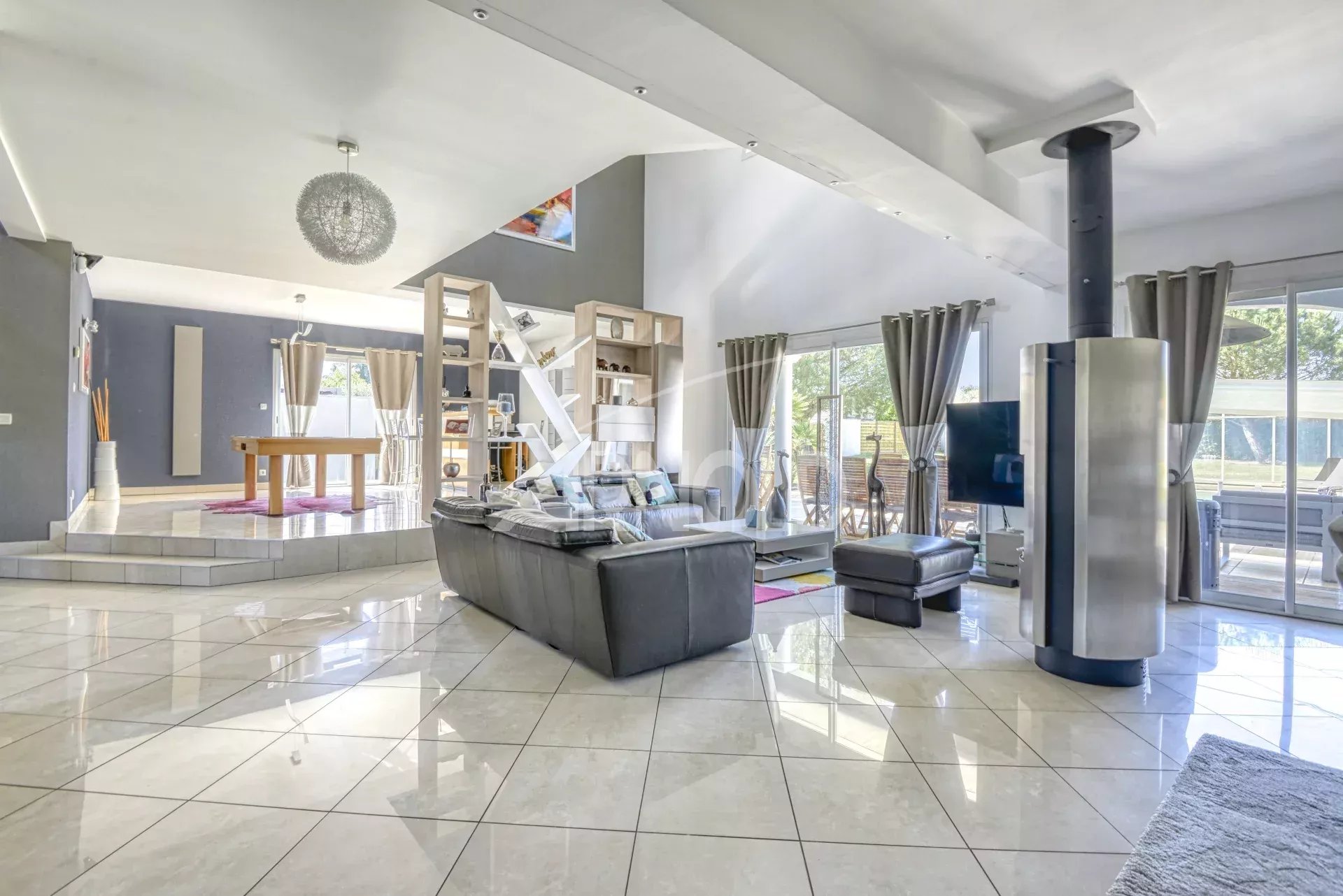 Intérieur d'une maison contemporaine avec salon lumineux et accès à la piscine.