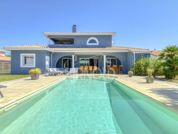 Maison contemporaine avec piscine à Les Sorinières, vue sur le jardin et la piscine.