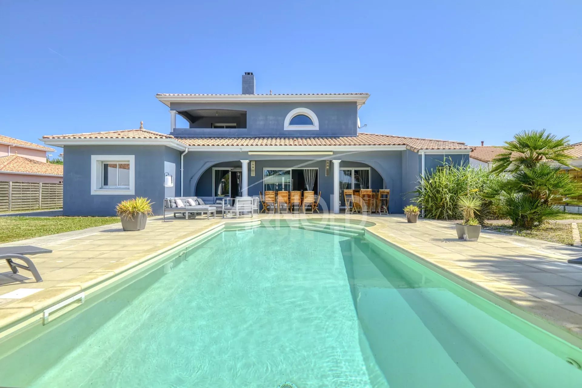 Maison contemporaine avec piscine à Les Sorinières, vue sur le jardin et la piscine.