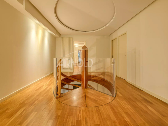 Wooden staircase with glass railing in a modern apartment.
