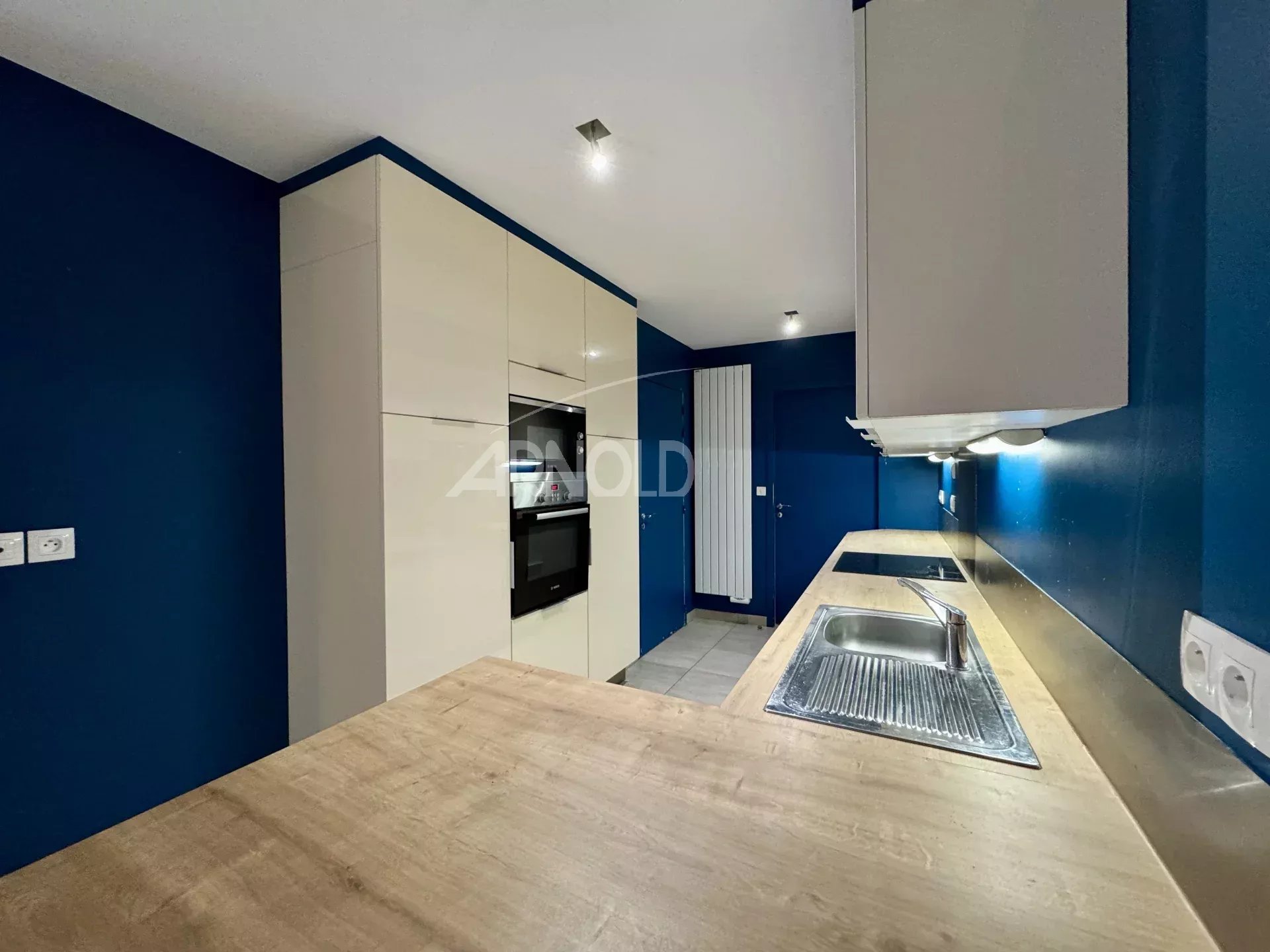 Kitchen of a 7-room apartment in Nantes Modern kitchen in a 7-room apartment in Nantes, with wooden worktops and blue walls.