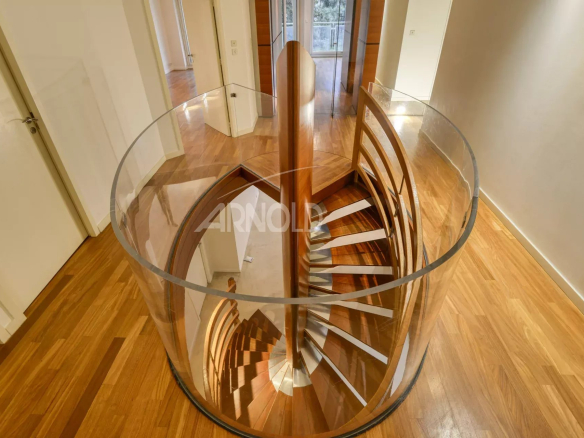 Spiral staircase made of wood and glass in a modern apartment.