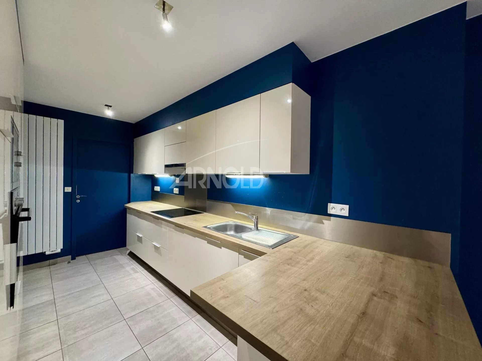 Kitchen of an apartment in Nantes Modern kitchen with blue walls and white furniture in an apartment in Nantes.