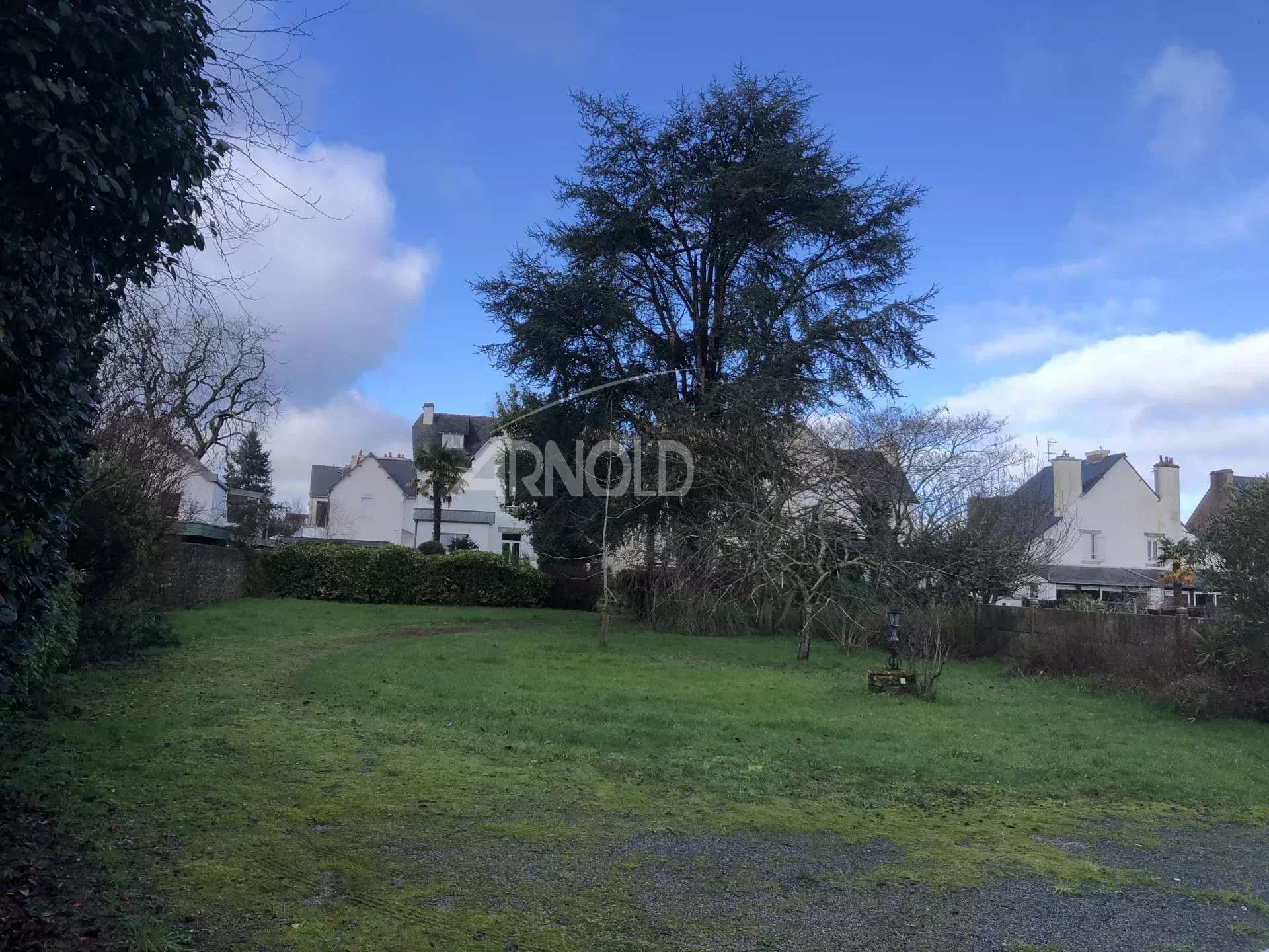 Terrain constructible à Vannes Terrain constructible de 2022 m² à Vannes, avec arbres et maisons environnantes.
