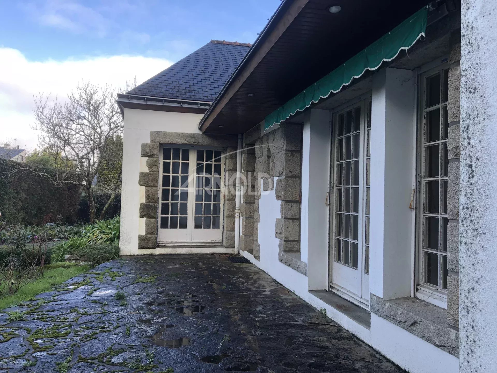 Terrain constructible à Vannes Terrasse d'une maison à rénover sur un terrain constructible à Vannes, entourée de verdure.