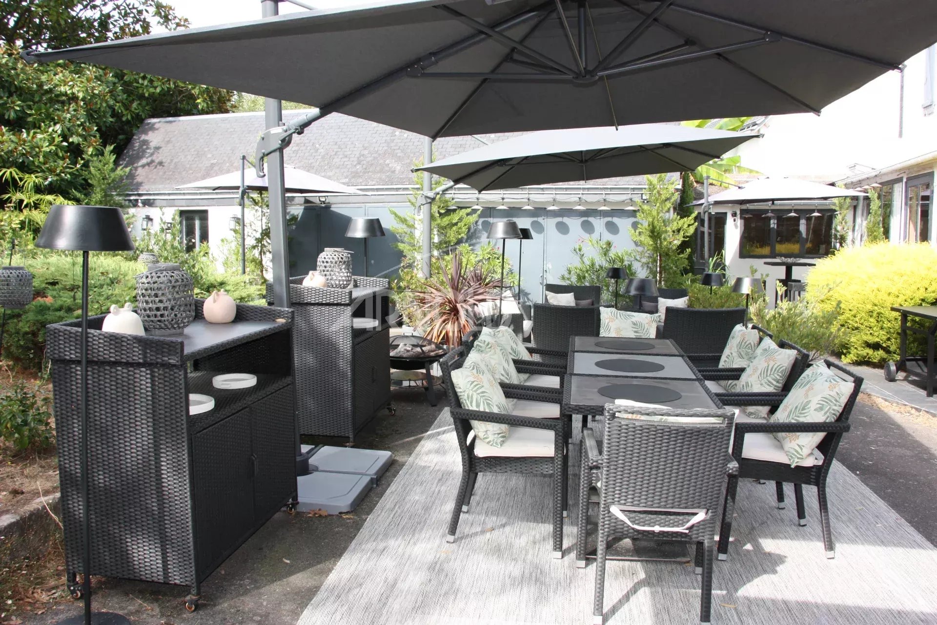 Terrasse de maison à Belz Terrasse aménagée avec mobilier en osier et parasols dans une maison à Belz.