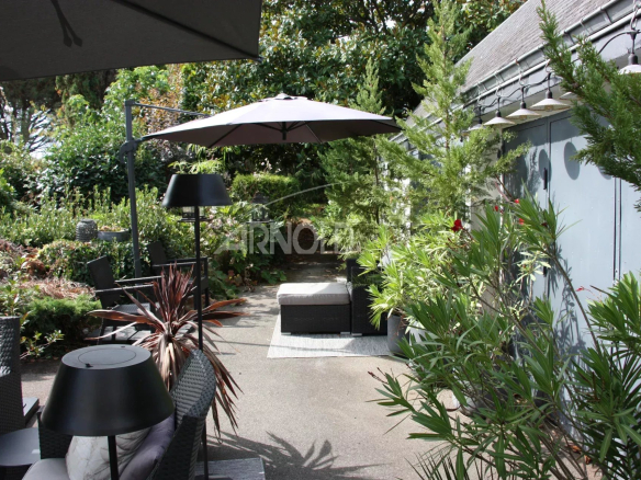Terrasse d'une maison avec mobilier de jardin et plantes, à Belz.