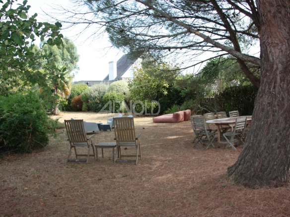 Jardin d'une maison à Belz avec des chaises en bois et un espace de vie extérieur.