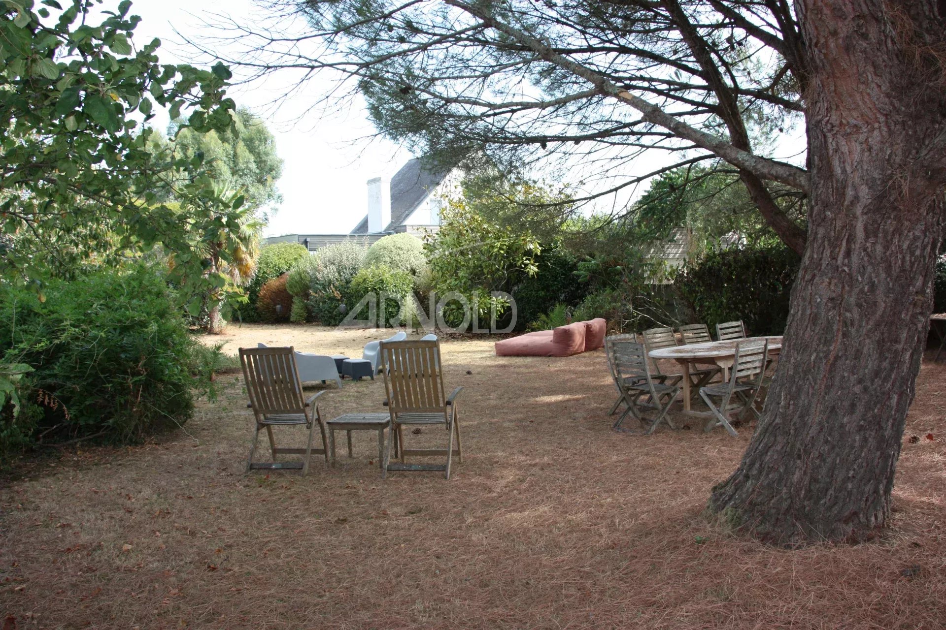 Jardin d’une maison à Belz Jardin d'une maison à Belz avec des chaises en bois et un espace de vie extérieur.
