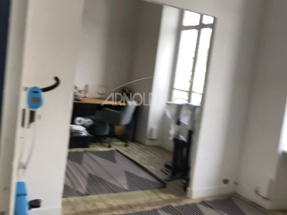 Interior of a house to be renovated in Vannes, showing an empty space with a rug and furniture.