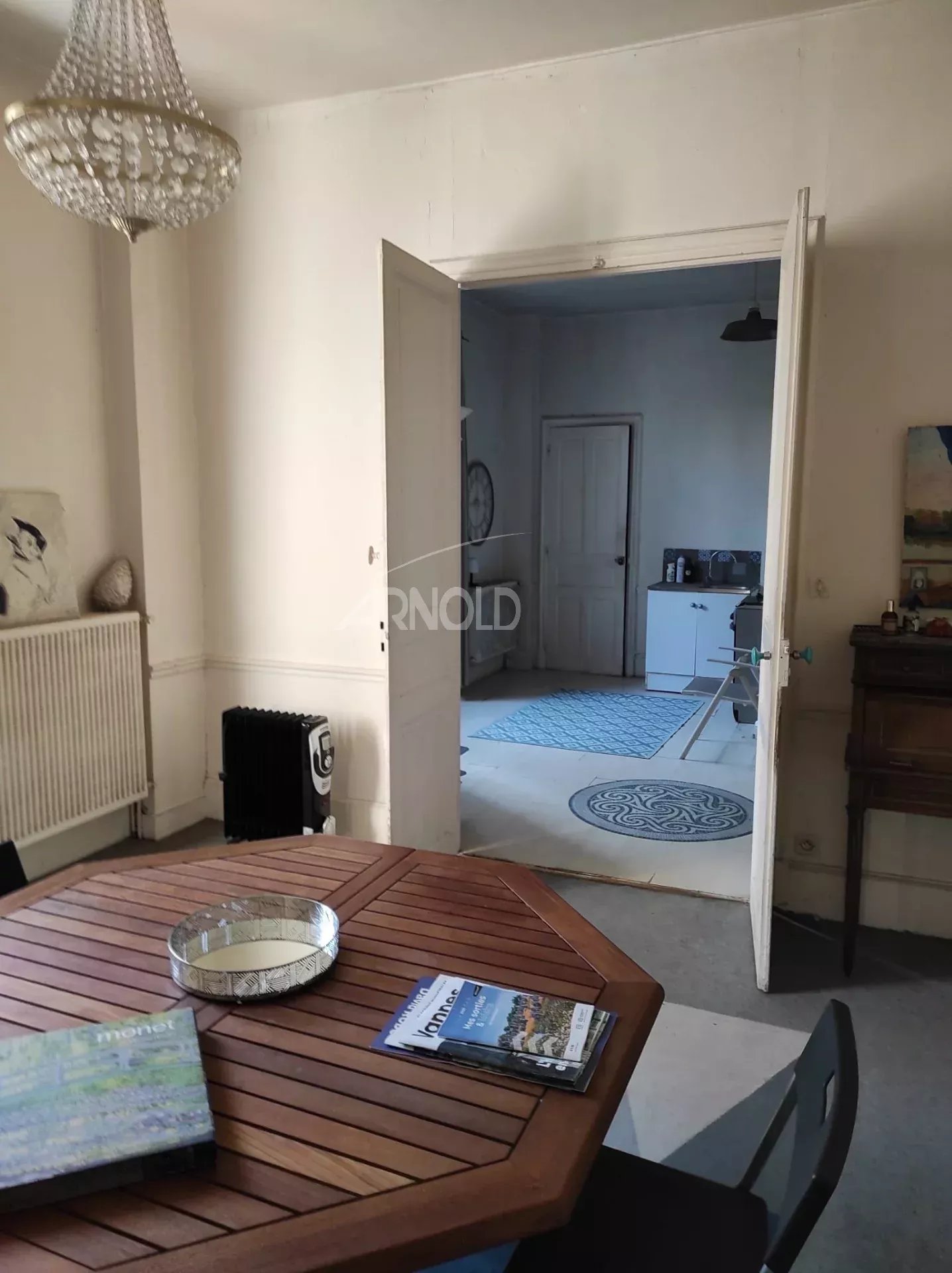 Townhouse to renovate in Vannes Interior of a bourgeois house to be renovated in Vannes, view of a room with a wooden table and an open door.