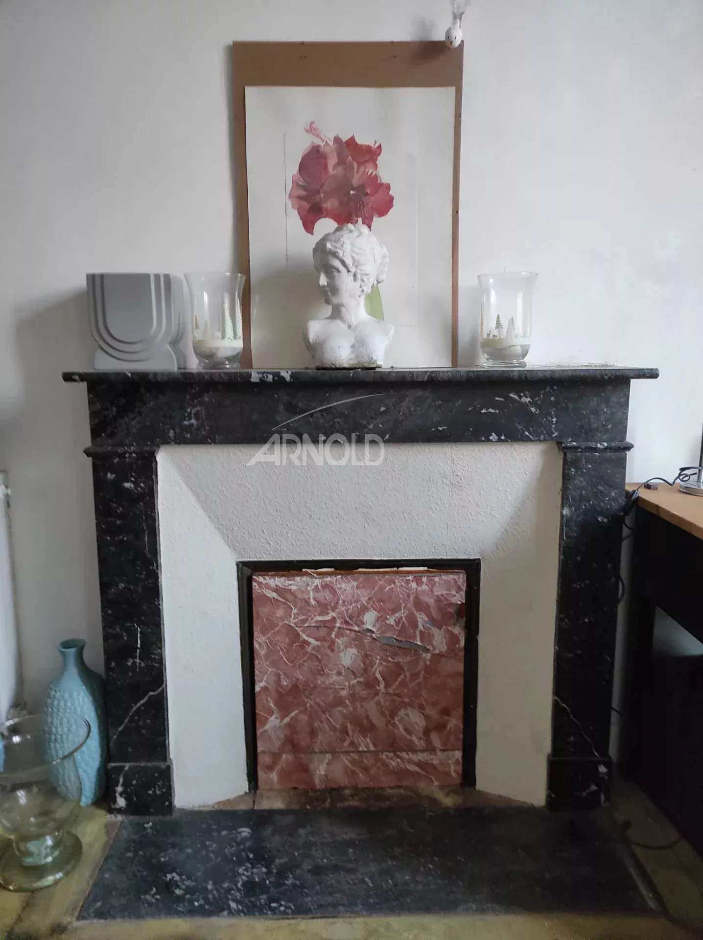 Indoor fireplace in Vannes Marble fireplace with a statue and decorations on an interior wall.