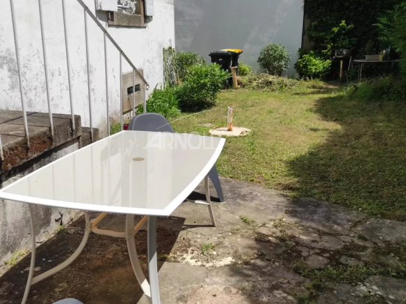Garden of a house to be renovated in Vannes with a table and chairs.