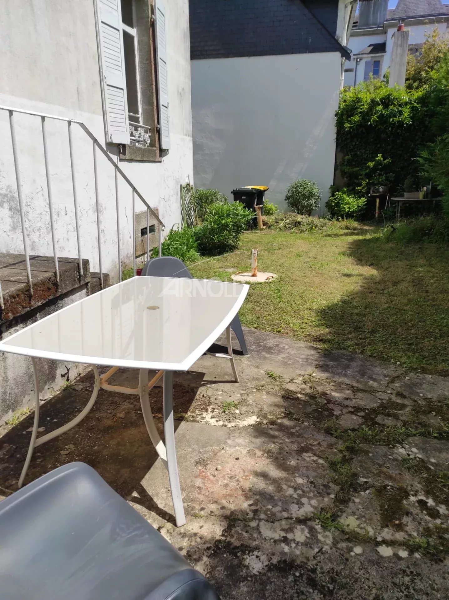Garden of a house to renovate in Vannes Garden of a house to be renovated in Vannes with a table and chairs.
