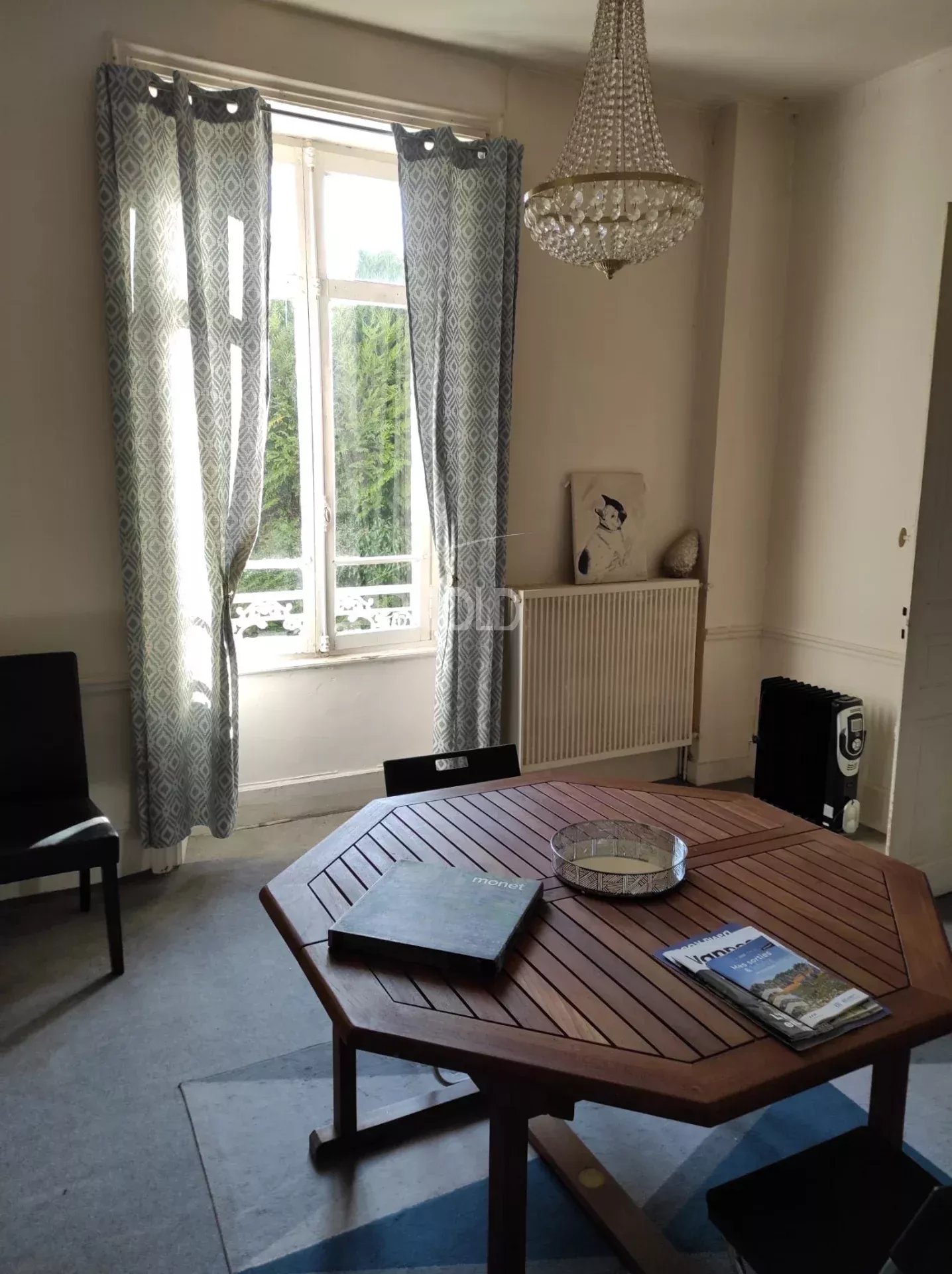 Interior of a house to renovate in Vannes Interior of a bourgeois house to be renovated in Vannes, with a wooden table and curtains.