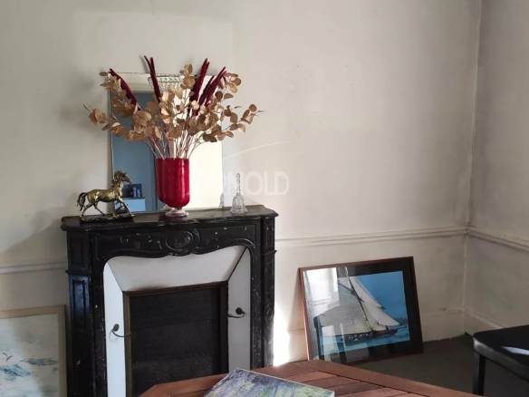 Interior of a bourgeois house to be renovated in Vannes, with fireplace and simple decoration.
