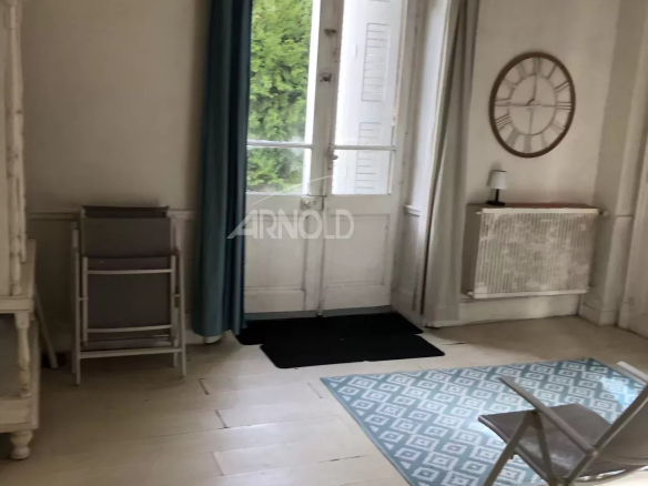 Interior of a bourgeois house to be renovated in Vannes, with a light floor and windows overlooking the outside.