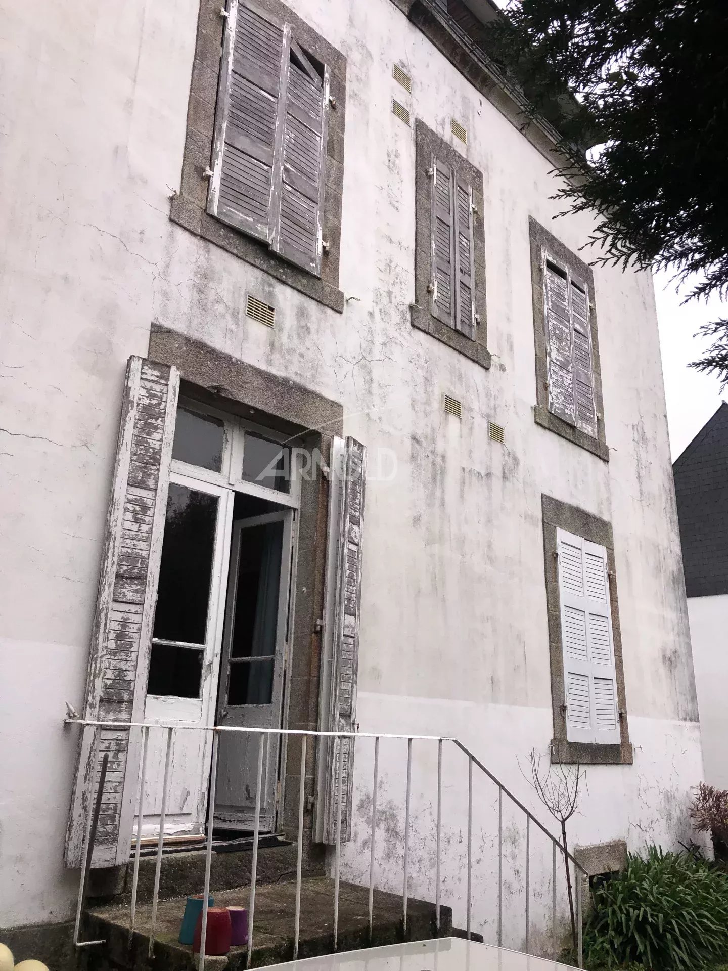 Townhouse to renovate in Vannes Facade of a bourgeois house to be renovated in Vannes, with wooden shutters and front door.