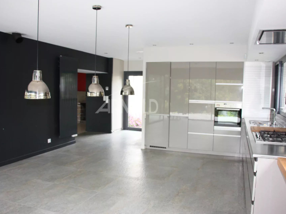 Intérieur d'une maison familiale moderne avec cuisine ouverte et salon lumineux.