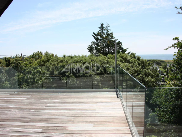 Terrasse en bois avec vue sur la mer et la végétation environnante à Sarzeau.