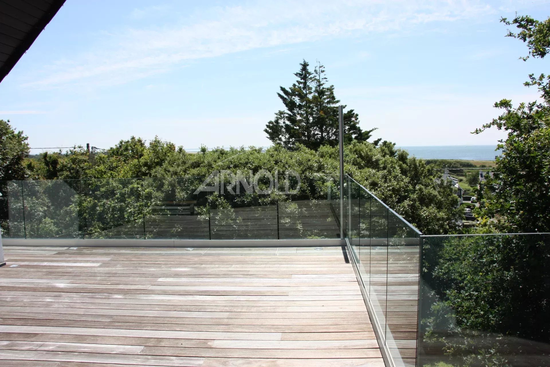 Terrasse avec vue à Sarzeau Terrasse en bois avec vue sur la mer et la végétation environnante à Sarzeau.