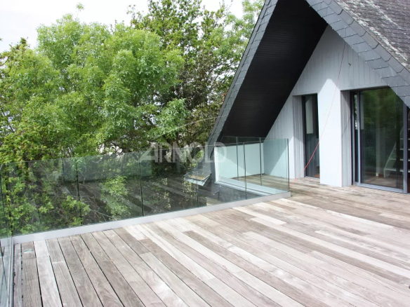 Terrasse en bois d'une maison avec vue sur la verdure, située à Sarzeau.