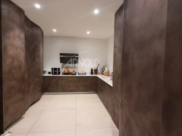 Cuisine moderne et spacieuse d'une maison contemporaine à Vannes, avec des meubles en bois et un éclairage doux.