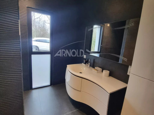 Salle de bain moderne avec meuble vasque et fenêtre donnant sur l'extérieur.