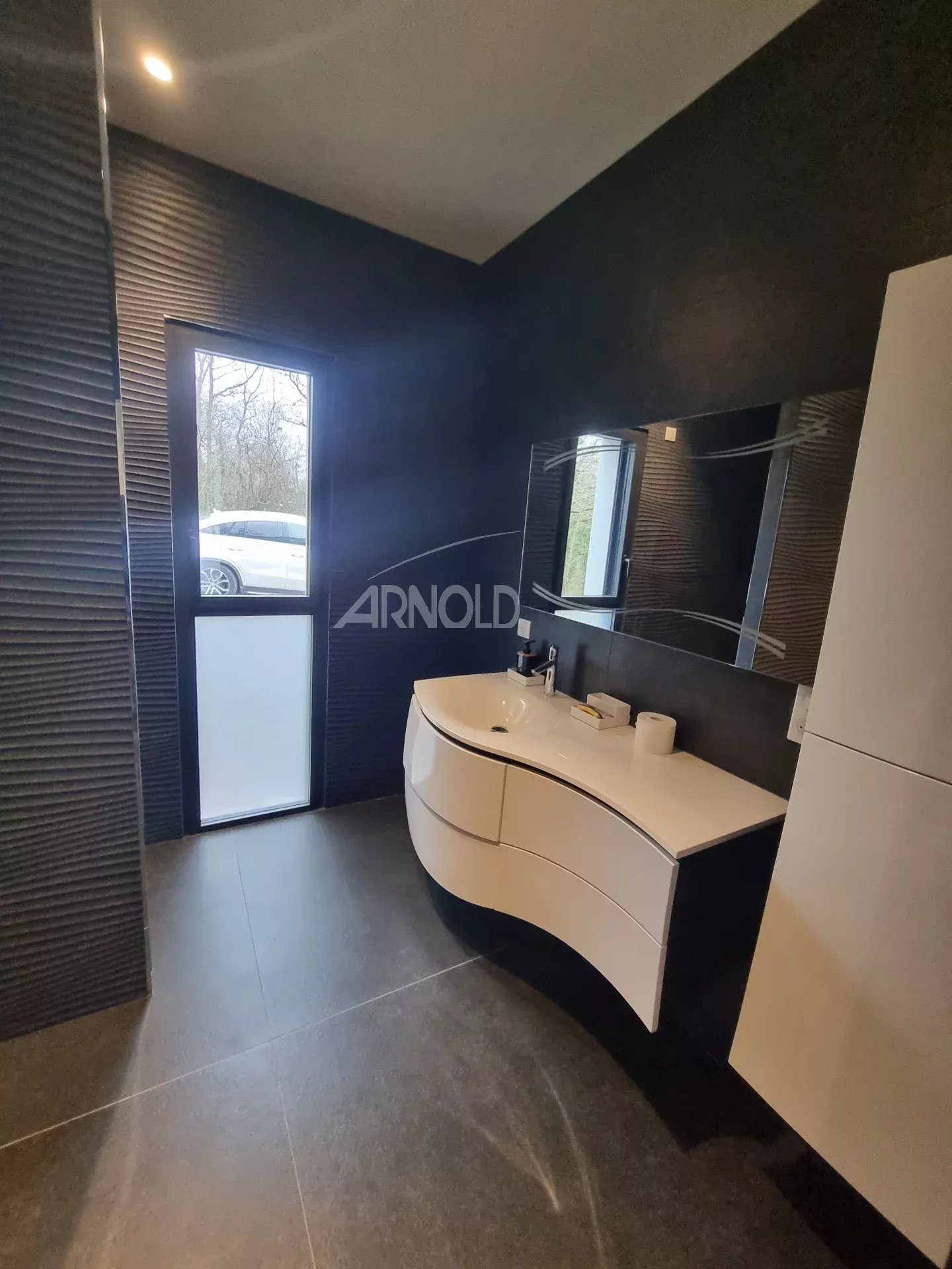Salle de bain contemporaine Salle de bain moderne avec meuble vasque et fenêtre donnant sur l'extérieur.