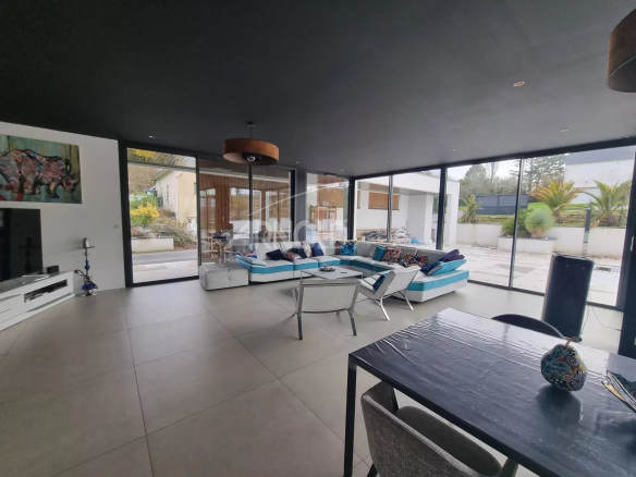 Intérieur d'une maison contemporaine à Vannes avec salon lumineux et cuisine ouverte.