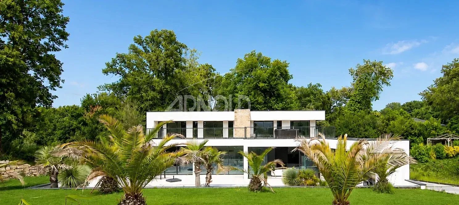 Maison contemporaine à Vannes Maison contemporaine avec jardin et palmiers à Vannes, entourée d'arbres.