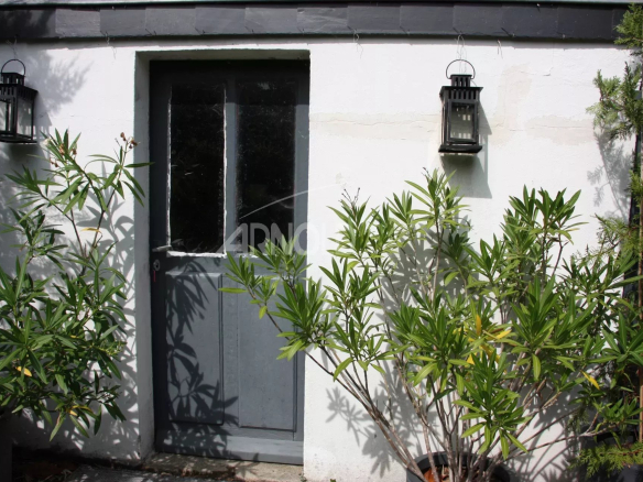 Entrance to a charming house in Belz, with lanterns and plants in front of the door.